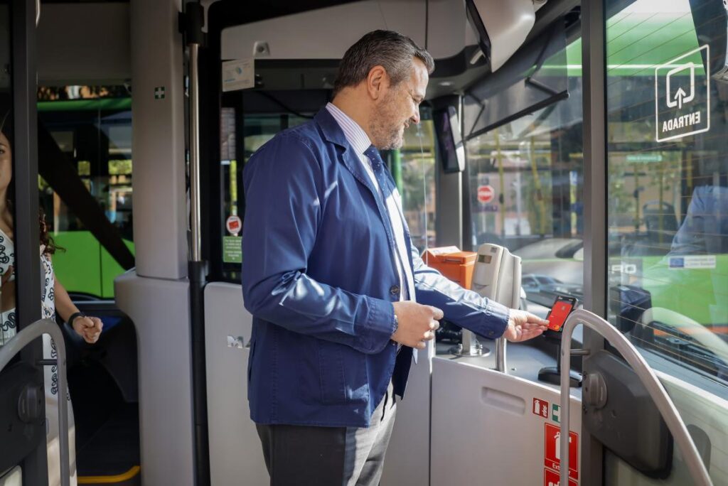 Hombre pagando con tarjeta en bus